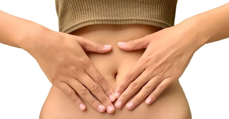 Eine Frau die ihre Hände auf ihrem Bauch hat. Vegane Nahrungsergänzungsmittel haben eine bessere Verträglichkeit und sind leichter verdaubar.